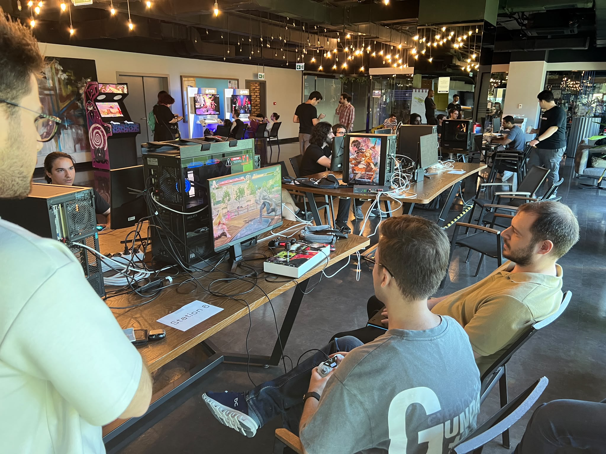 DOT Fighters event showing multiple setups, the arcade machine, and PS5 stations.